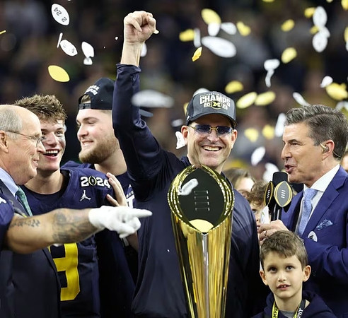 J.J. McCarthy (9), Zak Zinter (65), Jim Harbaugh, and National Championship Trophy