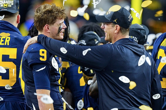 Zak Zinter (65), J.J. McCarthy (9), and Jim Harbaugh
