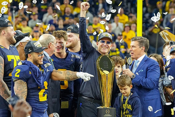Trevor Keegan (77), Zak Zinter (65), Blake Corum (2), J.J. McCarthy (9), Jim Harbaugh, and National Championship Trophy