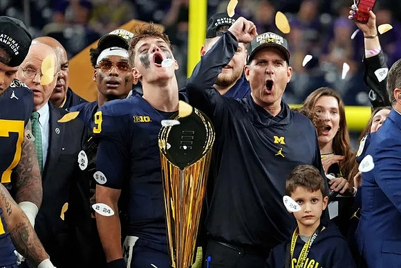 Will Johnson (2), J.J. McCarthy (9), Jim Harbaugh, Zak Zinter (65), and National Championship Trophy