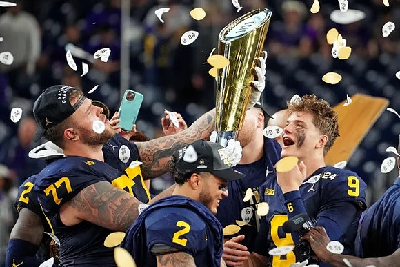 Trevor Keegan (77), Blake Corum (2), J.J. McCarthy (9), Zak Zinter (65), and National Championship Trophy