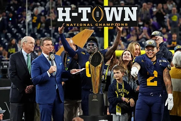 Mike Sainristil (0), Blake Corum (2), Jim Harbaugh, and National Championship Trophy