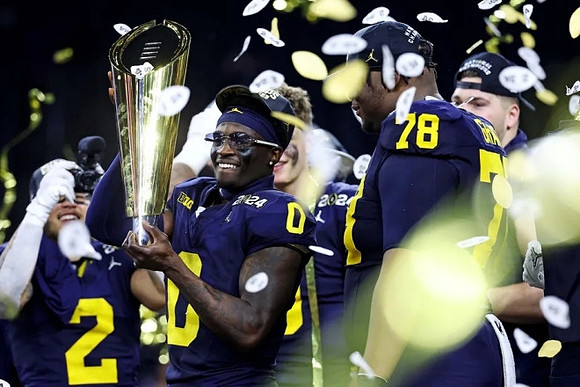 Blake Corum (2), Mike Sainristil (0), Kenneth Grant (78), Zak Zinter (65), and National Championship Trophy