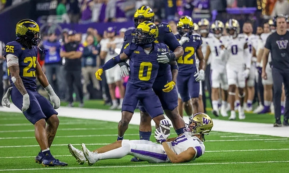 Junior Colson (25), Mike Sainristil (0), Kenneth Grant (78), and Josh Wallace (12)