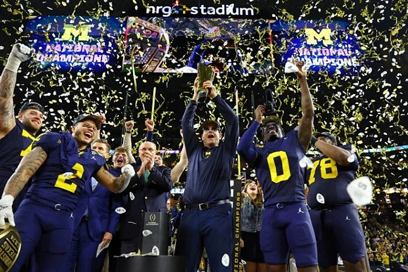 Trevor Keegan (77), Blake Corum (2), J.J. McCarthy (9), Jim Harbaugh, Mike Sainristil (0), Kenneth Grant (78), and National Championship Trophy