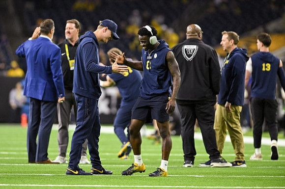 Mike Sainristil (0) and Michigan Team