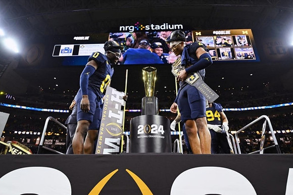 Mike Sainristil (0), Will Johnson (2), Kris Jenkins (94), and National Championship Trophy