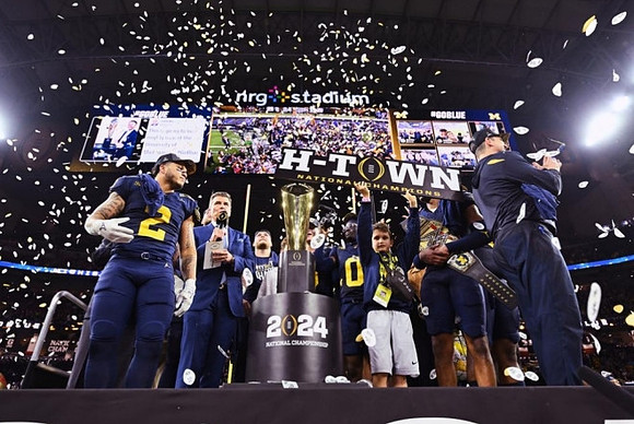 Blake Corum (2), Mike Sainristil (0), Will Johnson (2), Jim Harbaugh, and National Championship Trophy