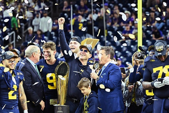Blake Corum (2), J.J. McCarthy (9), Zak Zinter (65), Jim Harbaugh, Kenneth Grant (78), and National Championship Trophy