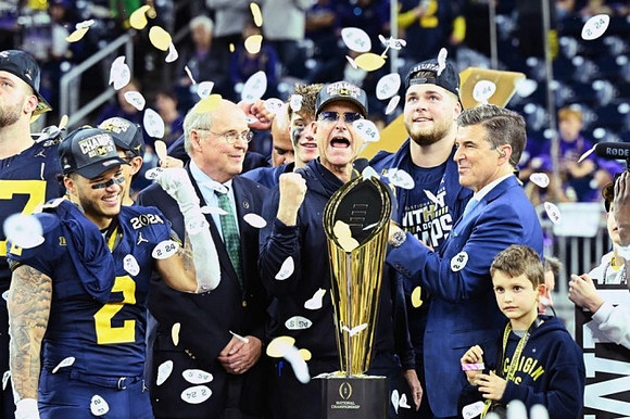 Trevor Keegan (77), Blake Corum (2), J.J. McCarthy (9), Jim Harbaugh, and National Championship Trophy