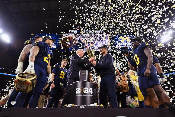 Trevor Keegan (77), Blake Corum (2), J.J. McCarthy (9), Jim Harbaugh, Mike Sainristil (0), Alessandro Lorenzetti (89), and National Championship Trophy
