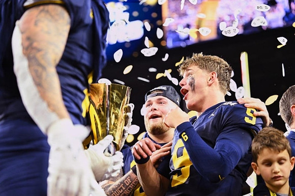 National Championship Trophy, Zak Zinter (65), and J.J. McCarthy (9)