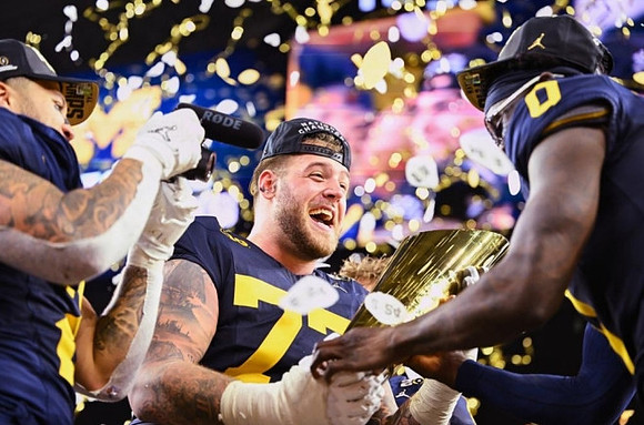 Blake Corum (2), Trevor Keegan (77), Mike Sainristil (0), and National Championship Trophy