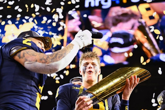 Blake Corum (2), J.J. McCarthy (9), and National Championship Trophy