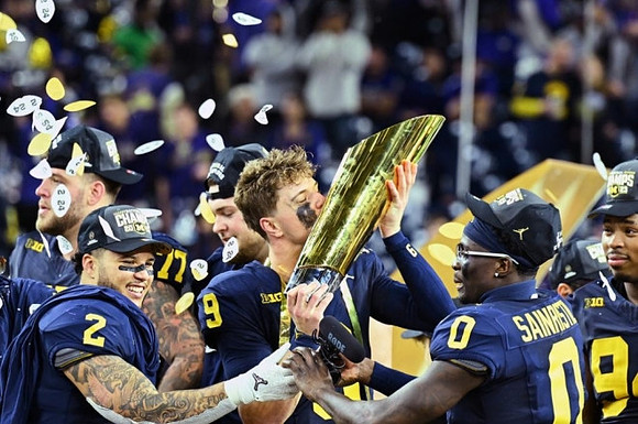 Trevor Keegan (77), Blake Corum (2), Zak Zinter (65), J.J. McCarthy (9), Mike Sainristil (0), Kris Jenkins (94), and National Championship Trophy