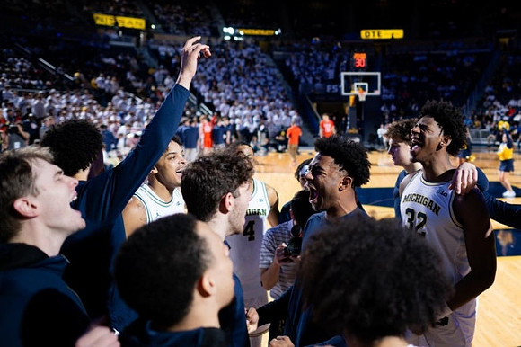 Jace Howard (25) and Michigan Team