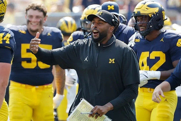 Mason Graham (55), Sherrone Moore, and TJ Guy (42)