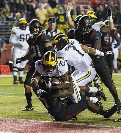 Karan Higdon (22), Kekoa Crawford (1), and Michael Onwenu (50)