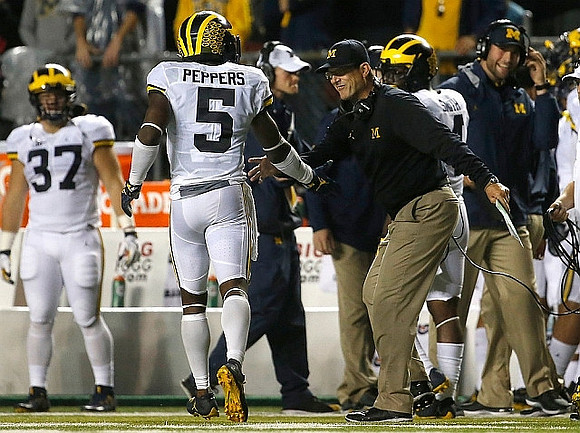 Bobby Henderson (37), Jabrill Peppers (5), Jim Harbaugh, and De'Veon Smith (4)