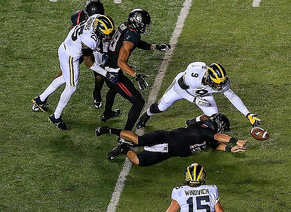 Dymonte Thomas (25), Chase Winovich (15), and Mike McCray (9)