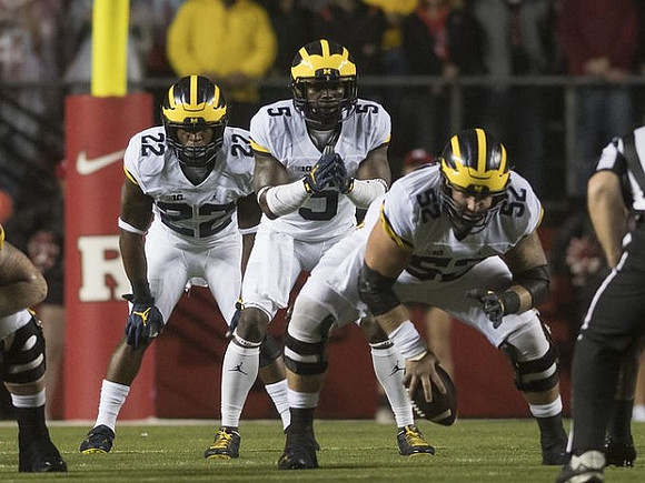 Karan Higdon (22), Jabrill Peppers (5), and Mason Cole (52)
