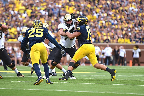 Dymonte Thomas (25) and Chase Winovich (15)