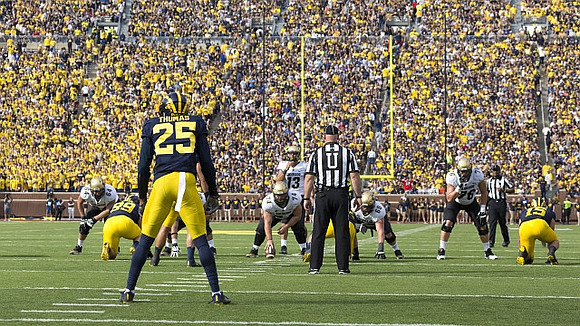Matthew Godin (99), Dymonte Thomas (25), and Chase Winovich (15)