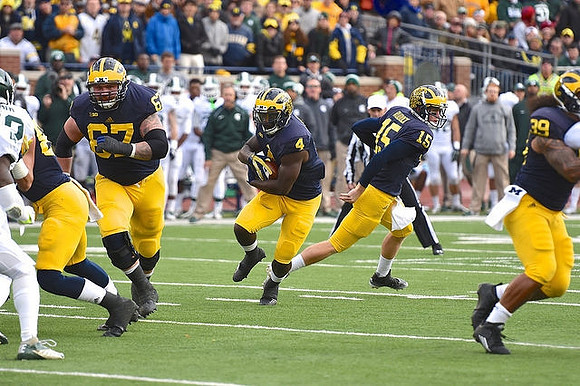 Kyle Kalis (67), De'Veon Smith (4), Jake Rudock (15), and Sione Houma (39)