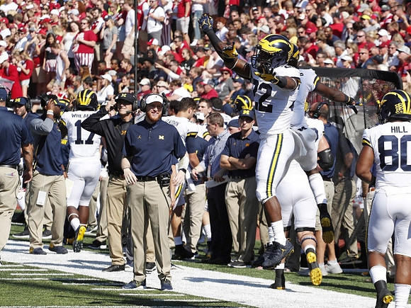 Jim Harbaugh, Jay Harbaugh, Karan Higdon (22), and Khalid Hill (80)