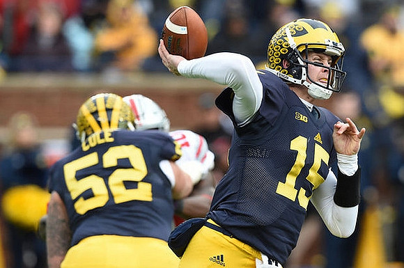 Mason Cole (52) and Jake Rudock (15)