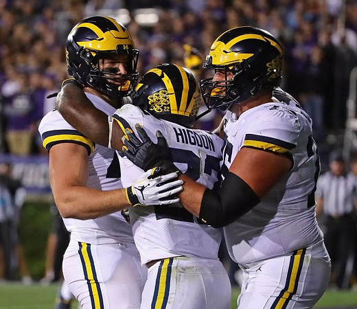 Ben Mason (42), Karan Higdon (22), and Jon Runyan Jr. (75)