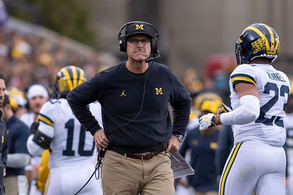 Devin Bush (10), Jim Harbaugh, and Tyree Kinnel (23)