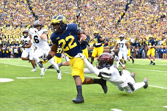 Karan Higdon (22), Patrick Kugler (57), Juwann Bushell-Beatty (76), and John O'Korn (8)