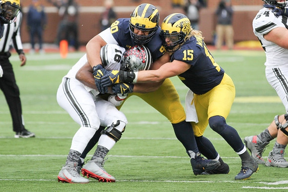 Bryan Mone (90) and Chase Winovich (15)