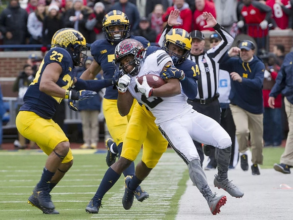 Tyree Kinnel (23), Khaleke Hudson (7), and Josh Metellus (14)