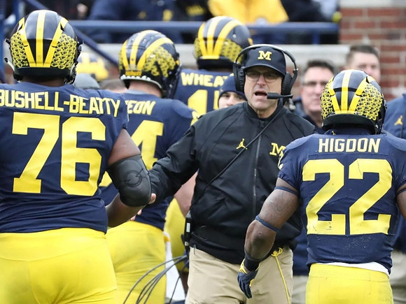 Juwann Bushell-Beatty (76), Sean McKeon (84), Tyrone Wheatley Jr. (17), Jim Harbaugh, and Karan Higdon (22)