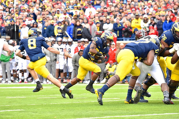 John O'Korn (8), Karan Higdon (22), Tyrone Wheatley Jr. (17), and Juwann Bushell-Beatty (76)
