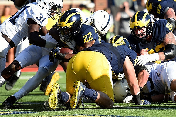 Karan Higdon (22), Henry Poggi (19), Mason Cole (52), and Kyle Kalis (67)