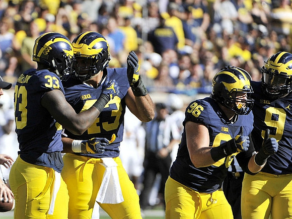 Taco Charlton (33), Chris Wormley (43), Ryan Glasgow (96), and Mike McCray (9)