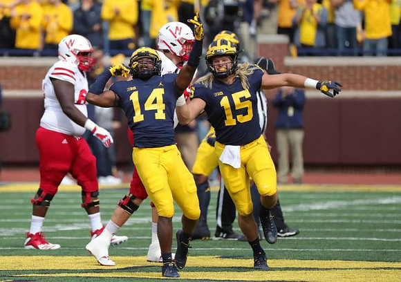 Josh Metellus (14) and Chase Winovich (15)