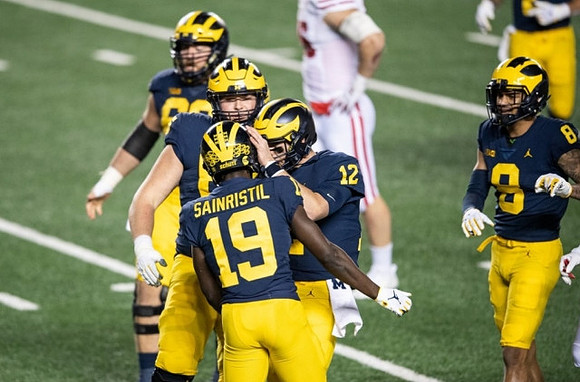 Mike Sainristil (19), Cade McNamara (12), and Ronnie Bell (8)