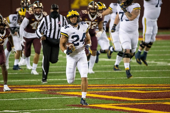 Ben Mason (42), Zach Charbonnet (24), and Jalen Mayfield (73)