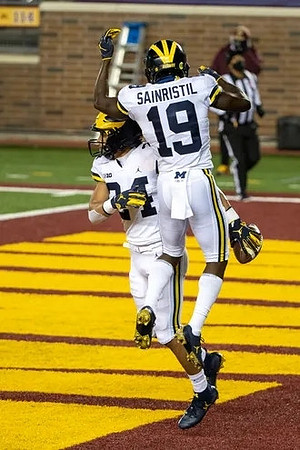 Zach Charbonnet (24) and Mike Sainristil (19)