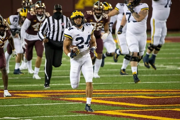 Ben Mason (42), Zach Charbonnet (24), and Jalen Mayfield (73)