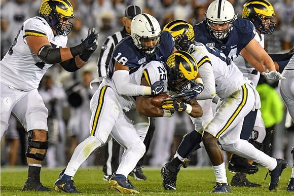 Ben Bredeson (74), Hassan Haskins (25), and Nick Eubanks (82)