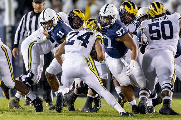 Jon Runyan Jr. (75), Zach Charbonnet (24), Ben Bredeson (74), and Michael Onwenu (50)