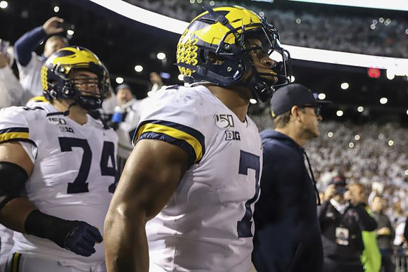 Ben Bredeson (74), Khaleke Hudson (7), and Jim Harbaugh
