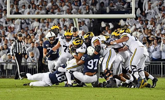 Nick Eubanks (82), Jon Runyan Jr. (75), Zach Charbonnet (24), and Michael Onwenu (50)