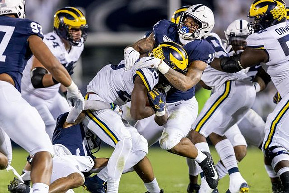 Ben Bredeson (74), Hassan Haskins (25), and Michael Onwenu (50)