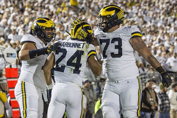 Jon Runyan Jr. (75), Zach Charbonnet (24), and Jalen Mayfield (73)